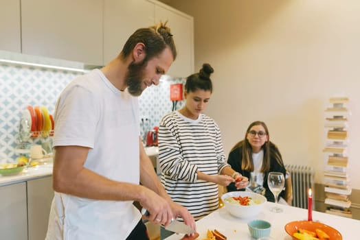 A lively kitchen with friends happily cooking a meal, sharing laughter and enjoying great conversation
