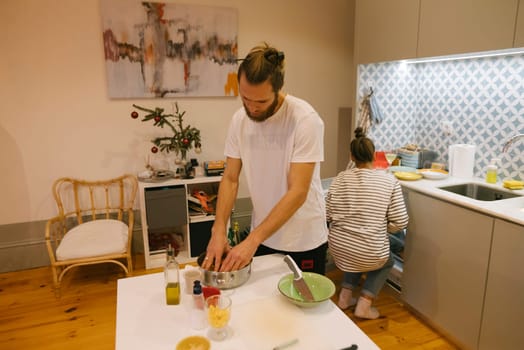 A couple happily enjoys cooking together in a spacious, modern kitchen environment they love very much