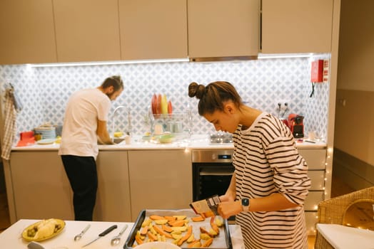 A loving couple enjoys cooking delicious meals together in a stylish and beautifully designed kitchen