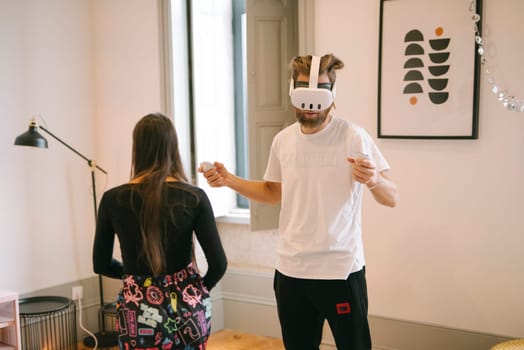 A humorous VR moment shows someone playing a game while another watches in a stylishly designed room