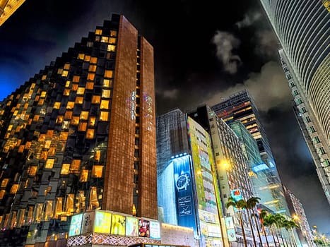 Hong Kong, China - April 05, 2024 - Vibrant urban skyline of Hong Kong showcases stunning skyscrapers illuminated at night with bustling streets below.