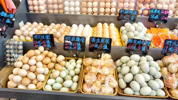 Hong Kong, China - April 09, 2024: Brightly colored eggs are arranged for sale in a market stall, highlighting the variety available to shoppers in Hong Kong.
