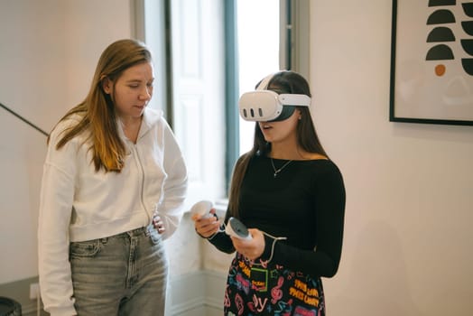 Two young women are actively engaging and having fun with a virtual reality headset in a sleek, modern setting