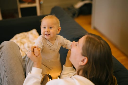 A delightful moment showcasing a parent interacting with a smiling baby, celebrating love and connection.