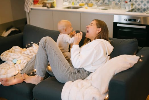 In a delightful and joyful interaction, a mother is engaging with her baby in a warm and cozy home setting