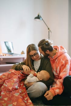 A warm and intimate moment lovingly shared by caring parents with their adorable baby in a stylish and cozy setting