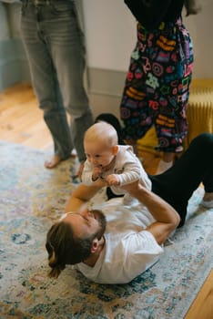 A joyful moment of an adult happily playing with a baby on a vibrant rug, capturing pure love and connection