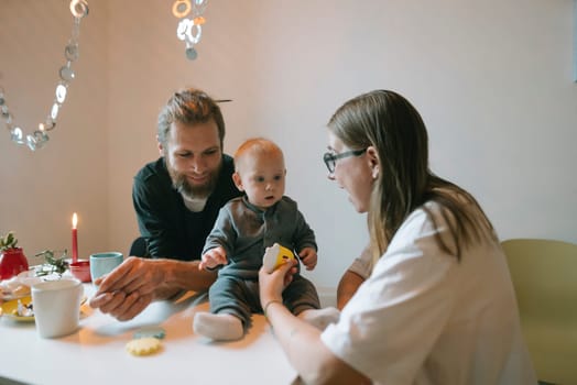 A heartwarming scene of a loving family joyfully interacting with their adorable baby during a cozy home moment