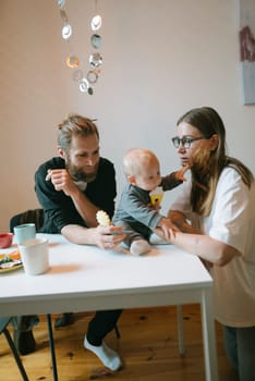A truly joyful and heartwarming moment of a loving family engaging playfully with their baby at a cozy table