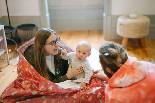 A heartwarming scene of a loving family playfully interacting with a joyful baby in a cozy, natural setting
