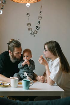 A truly heartwarming family moment with loving parents and their adorable baby enjoying delicious snacks together