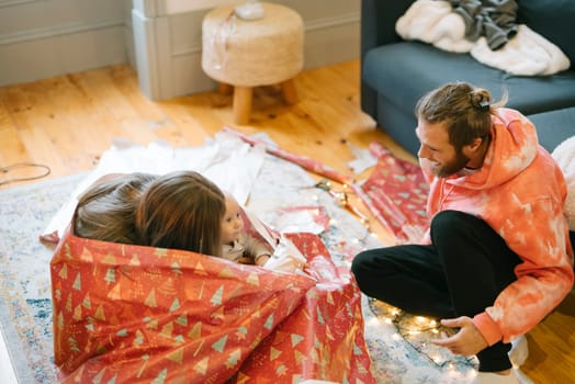 A couple delightfully enjoying the holiday spirit while wrapping gifts and creating beautiful memories together
