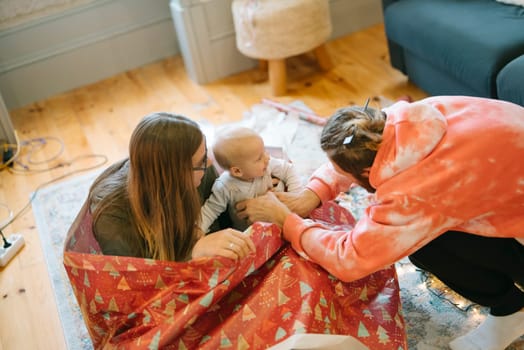 A heartwarming scene portrays a loving family immersed in joyful, playful moments with their adorable baby at home