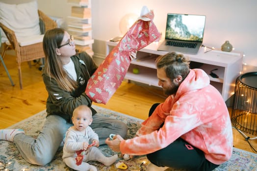 An incredibly joyful family scene with enthusiastic gift unwrapping during a vibrant festive celebration at home