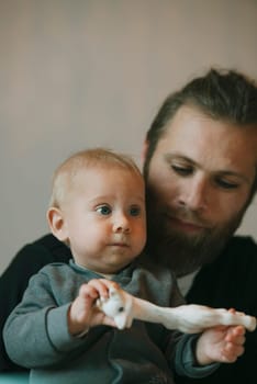 A heartwarming interaction between a loving father and his baby, enjoying a playful moment with a colorful toy