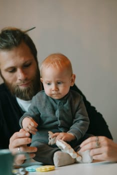 A heartwarming moment shows a father interacting lovingly with his adorable baby in a calm, peaceful setting