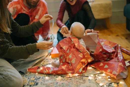A family is joyfully unwrapping colorful gifts together, which creates cherished holiday memories every year