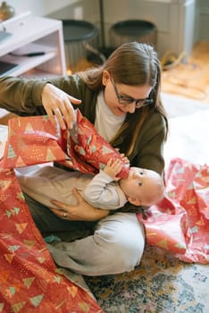 A parent joyfully unwraps a special gift together with their baby, creating a truly memorable bonding moment