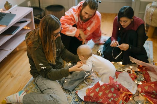 A joyful family moment captured during the holidays, featuring a cheerful baby with festive decorations