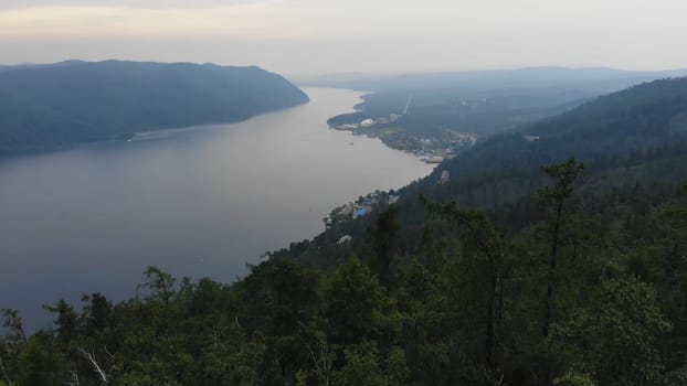 Vast yenisei river winds through a mountainous siberian landscape, showcasing the beauty of nature and tranquil atmosphere