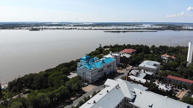 Aerial panorama revealing khabarovsk urban landscape, amur river shoreline, historic architecture, surrounding flood prone riverine terrain