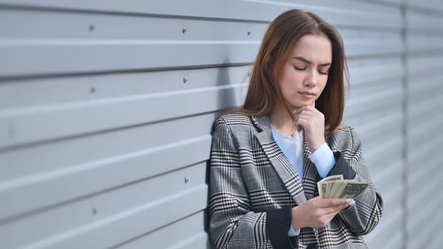 Distressed professional woman analyzing finances, checking remaining cash with concerned expression while seeking monetary relief strategies