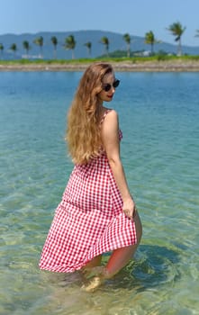 Bright blond young woman standing in sea in summer