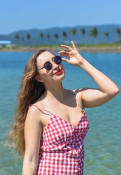 Bright blond young woman standing in sea in summer