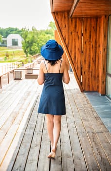 50 years old russian woman in short dress holding her hat on the sumer day