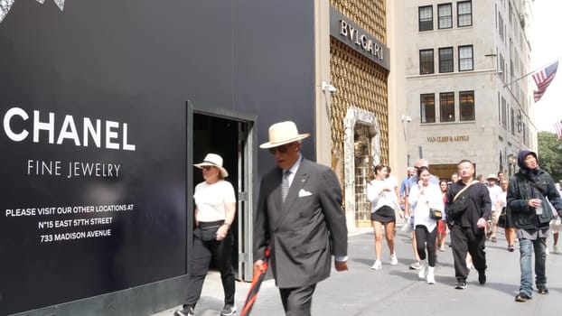 New York City, United States - 11 Sept 2023: Manhattan Midtown street, Fifth 5 avenue. American urban scene, USA. People pedestrians on sidewalk pavement. Boutique stores for luxury fashion shopping.