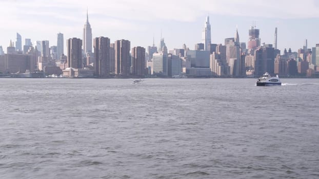 New York City, United States - 30 Aug 2023: Manhattan midtown skyline, ferry boat. Highrise skyscrapers from ferryboat. East river waterfront architecture near water. Empire State, Chrysler Building.