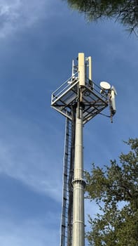 Cell tower with antennas against a blue sky. High quality photos