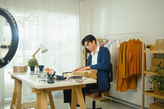 Business owner packing orders for delivery to costumer in his home office.