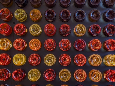 Sauternes bottles are meticulously arranged in a vibrant display, showcasing a range of colors from deep amber to golden yellow at a vineyard in the Bordeaux region.