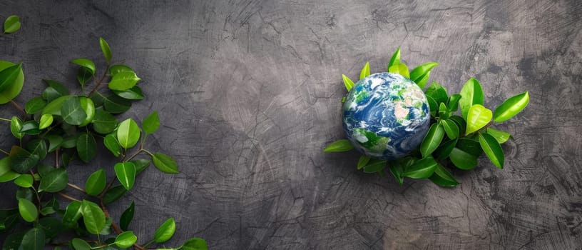 A vibrant globe surrounded by fresh green leaves rests against a textured gray backdrop, symbolizing nature's embrace and environmental care