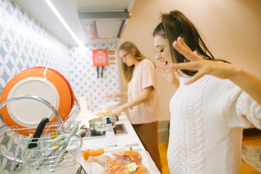 Two close friends sharing a delightful and joyful cooking experience together in a bright and modern kitchen