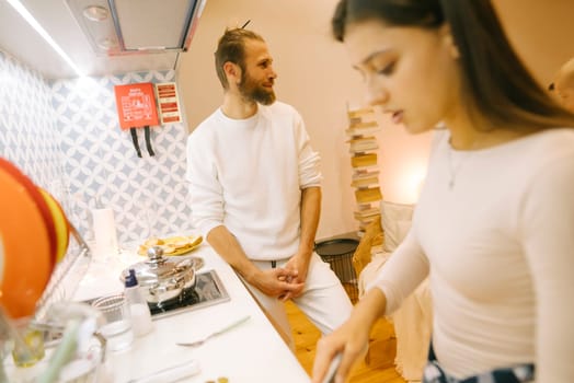 A loving couple is enjoying a shared cooking experience in a warm, inviting kitchen that feels cozy and delightful