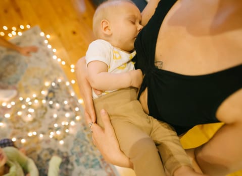 A beautiful tender moment of a mother lovingly breastfeeding her baby indoors, capturing the warmth and love shared