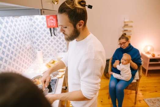 A loving family happily enjoys quality time together while cooking delicious meals in a stylish home kitchen