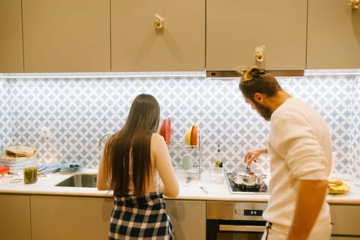 A loving couple shares a cozy and intimate cooking moment together in their stylishly designed kitchen