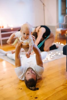 A joyful scene of a parent playing with a baby, showcasing love and connection in a warm atmosphere.