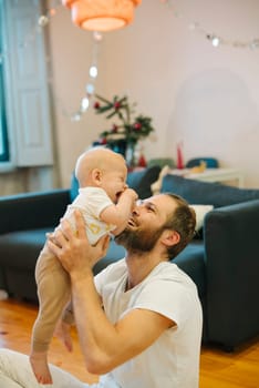 A truly heartwarming and delightful scene of a father joyfully and playfully engaging with his baby at home