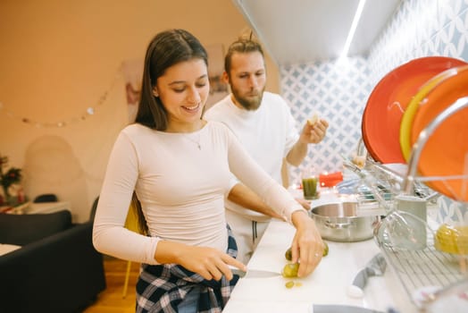 A young couple enjoys cooking delicious meals together, showcasing their teamwork and having fun in a bright kitchen