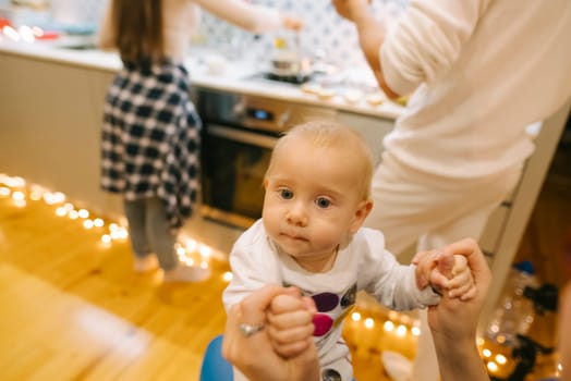 A sweet baby rests in a loving caregivers arms in a joyful kitchen filled with laughter, creating memories