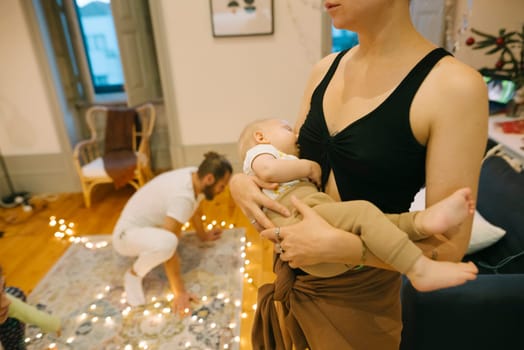 In a warm and cozy family scene, a loving mother is joyfully holding her baby as they decorate for the holidays