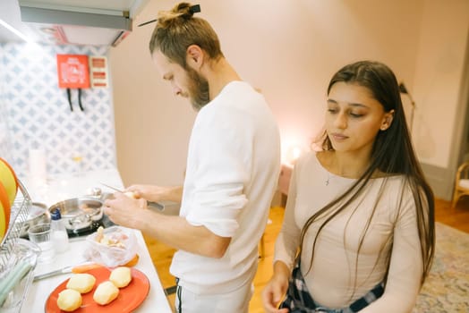 A couple joyfully enjoying their quality time while cooking delicious meals together in a stylish kitchen setting
