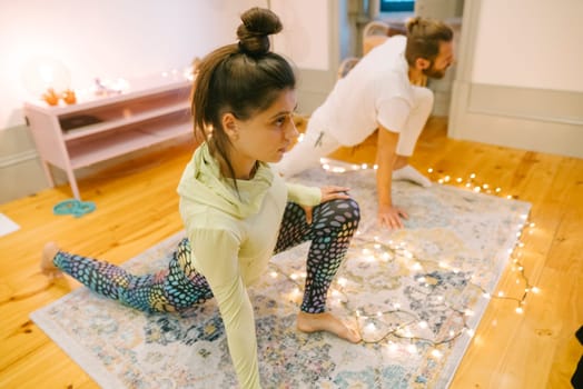 In a peaceful room, two individuals practice yoga together, fostering tranquility and deeper connection