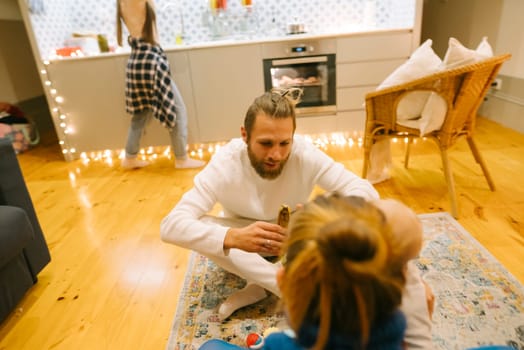 A delightful and joyful moment of family interaction occurs in a cozy, stylish living space adorned with warm lighting