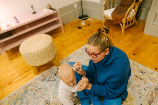 A loving bond is nurtured between a caregiver and a delightful baby in a cozy, warm, and inviting room