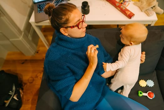 A heartwarming interaction unfolds between a loving parent and their adorable baby in a cozy living room space